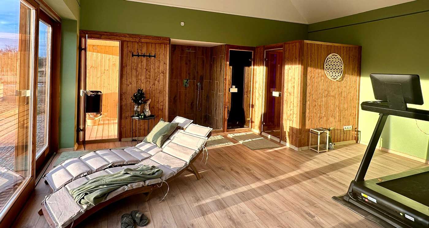 Moderner Wellnessraum mit Sauna, Liegen und Fitnessgerät in einem Ferienhaus in der ungarischen Puszta